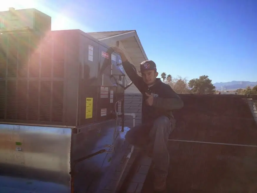 HVAC technician performing Boiler Repair on a rooftop unit in Olive